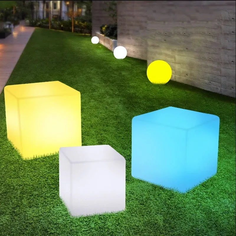 Square LED cube stool light in garden setting showing modern design with lighting