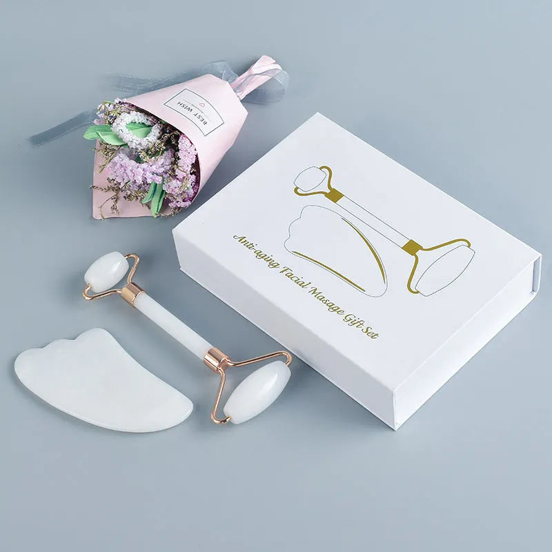 Natural white jade double-headed facial roller and gua sha board set on a plain background.