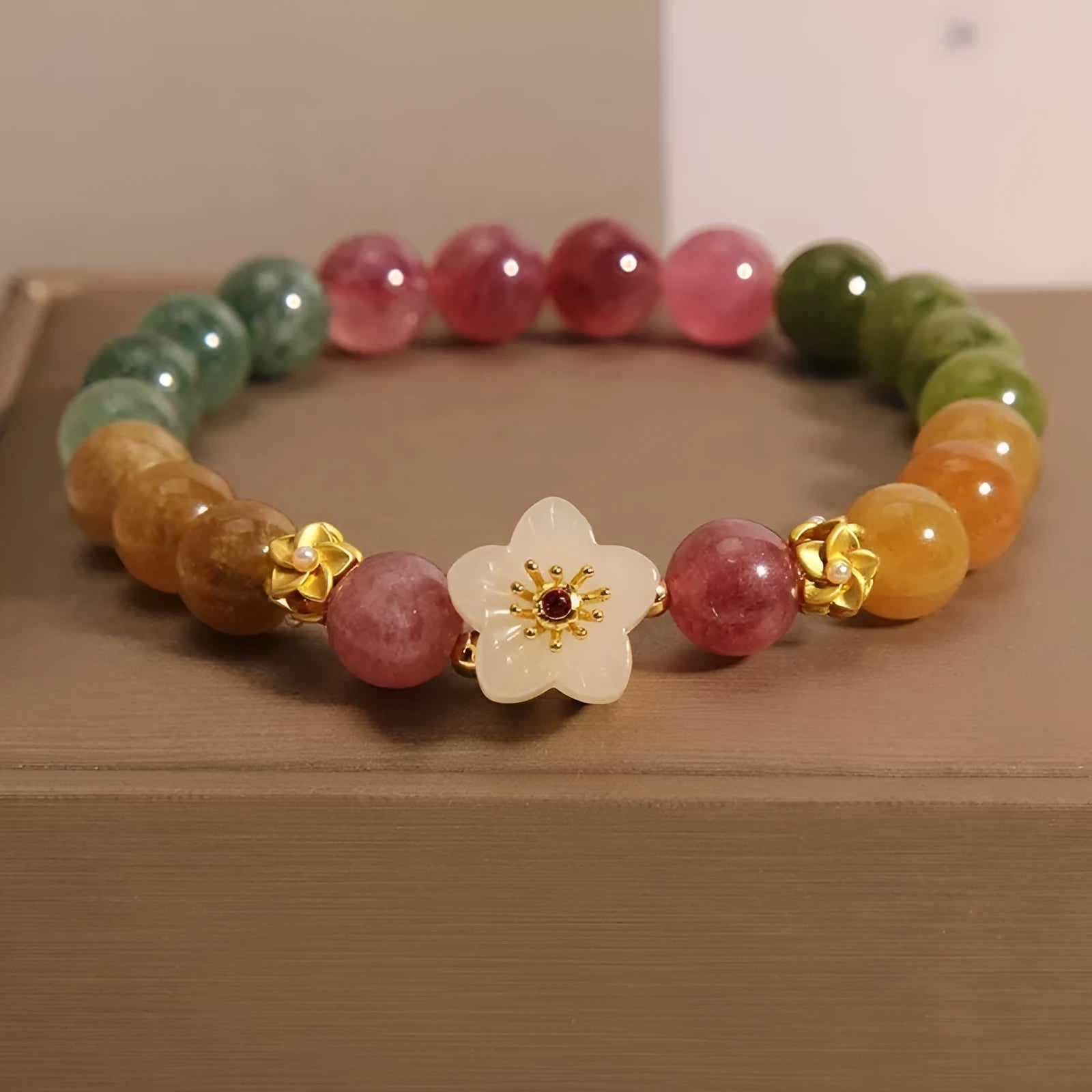 Natural colour tourmaline bracelet with electroplated finish showing geometric shape and delicate flower design