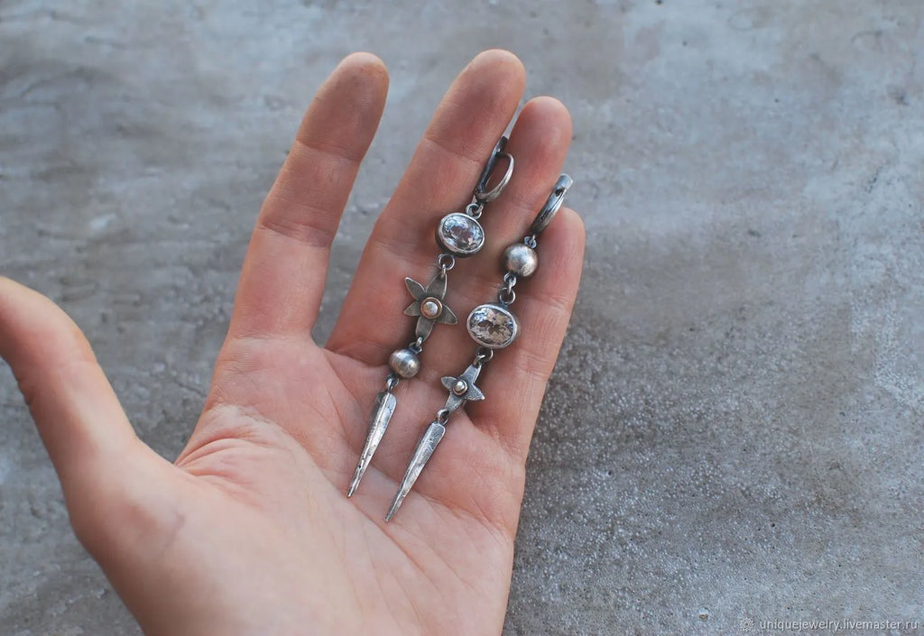 Geometric long pendant earrings with rhinestone drops in antique silver finish.