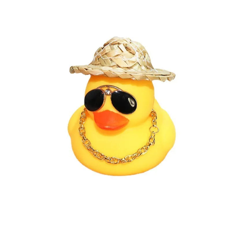 Yellow cartoon duck car ornament wearing a straw hat, with miniature sunglasses accessory.