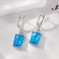 A pair of square geometric earrings with a gold electroplated finish on a copper base.