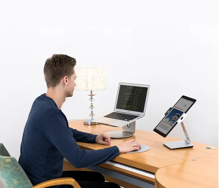 Silver folding aluminium phone and tablet stand with 360-degree rotation on desktop