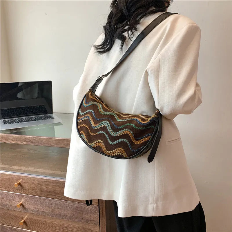 Women's woven straw crossbody bag with adjustable strap and interior organisation compartments