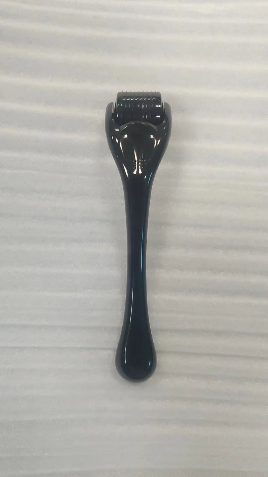 Black handle microneedle roller with purple wheel showing 540 needles, next to white and blue handle options.