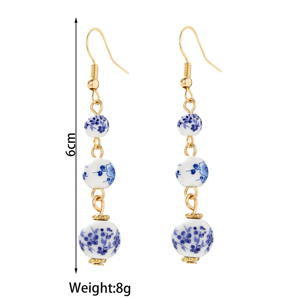 Long retro earrings with blue and white ceramic beads and geometric alloy parts.