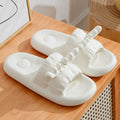 White deer horn pattern EVA flip-flop slippers with hollow-out design on a bathroom floor