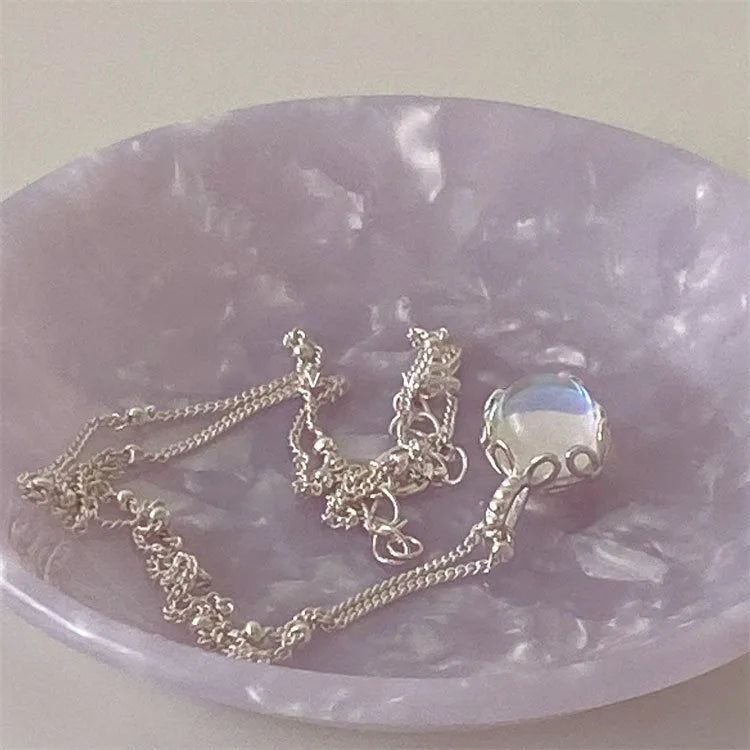 Silver geometric ornamental stone pendant on a curb chain necklace for women.