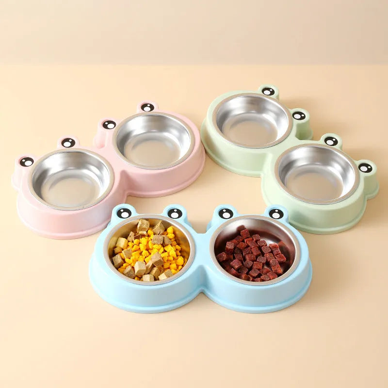 Blue stainless steel frog-shaped double pet bowl for food and water on a floor.