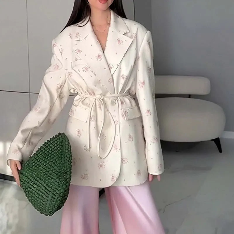 Women's floral print suit jacket with lace-up waist closure on a hanger.