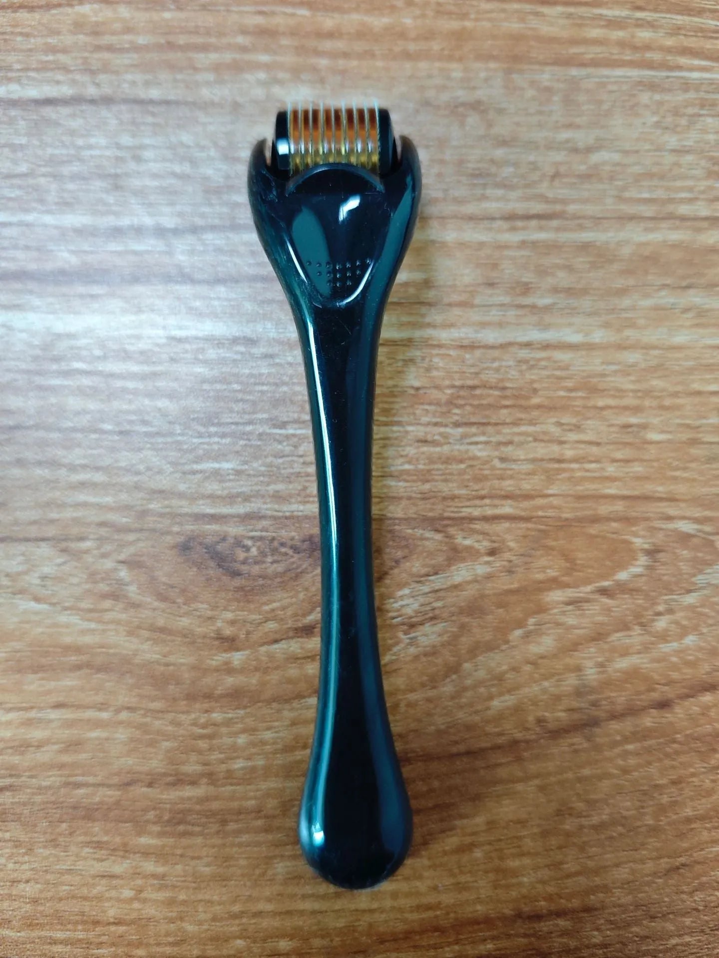 Black handle microneedle roller with purple wheel showing 540 needles, next to white and blue handle options.
