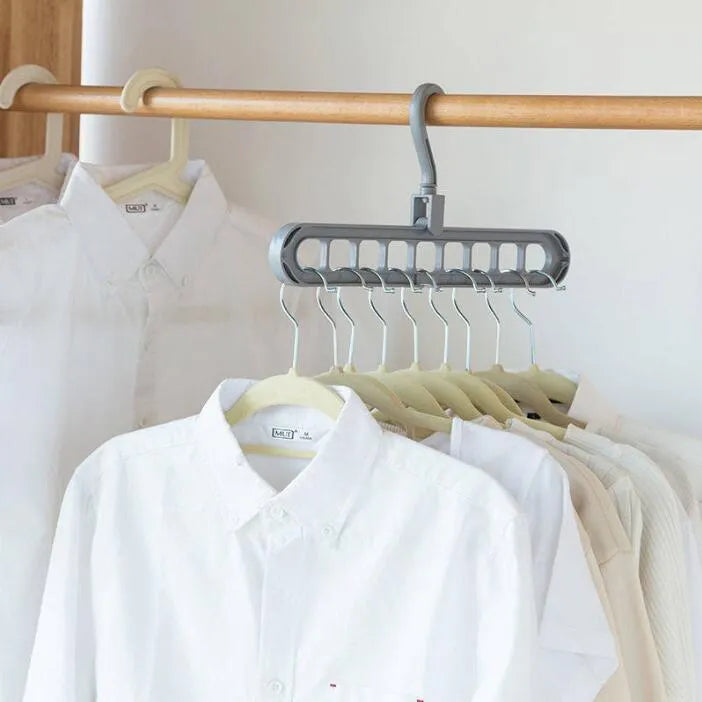 Plastic clothes hanger with rotating hook in pink and green colours on a rail.