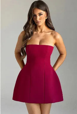 Women's solid colour backless tube dress with high waist and A-line skirt on a model.