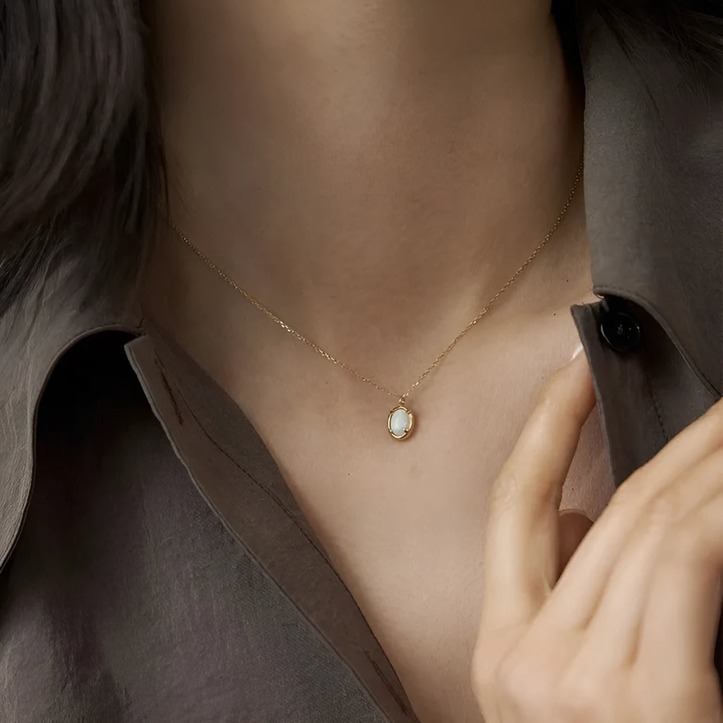 Oval geometric pendant necklace with jelly opal stone in silver plating, shown in golden and white gold colour options.