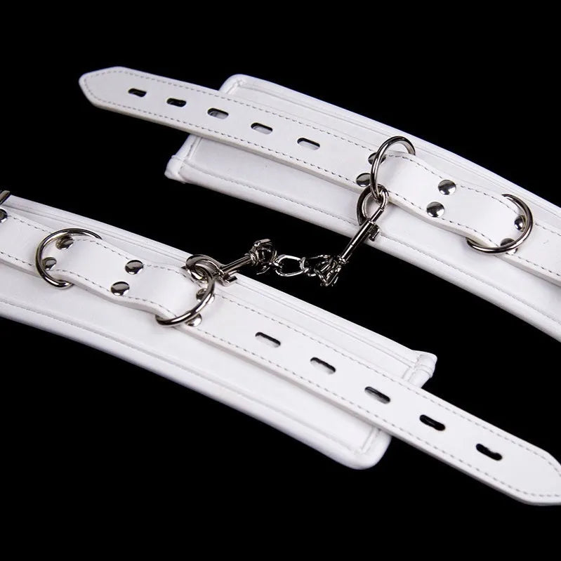 White PU sponge bondage set showing handcuffs, footcuffs, and a neck scarf arranged together.