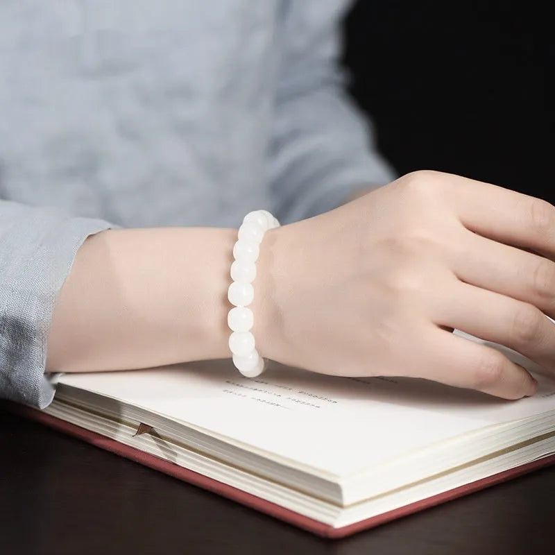 White jade barrel bead bracelet on wrist showing traditional Hetian jade material and barrel-shaped bead design