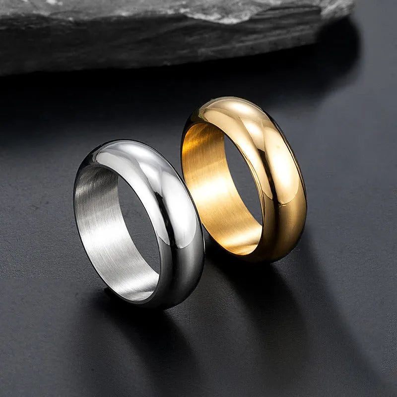 Glossy electroplated titanium steel ring in gold, black, and steel colours on a jewellery background.