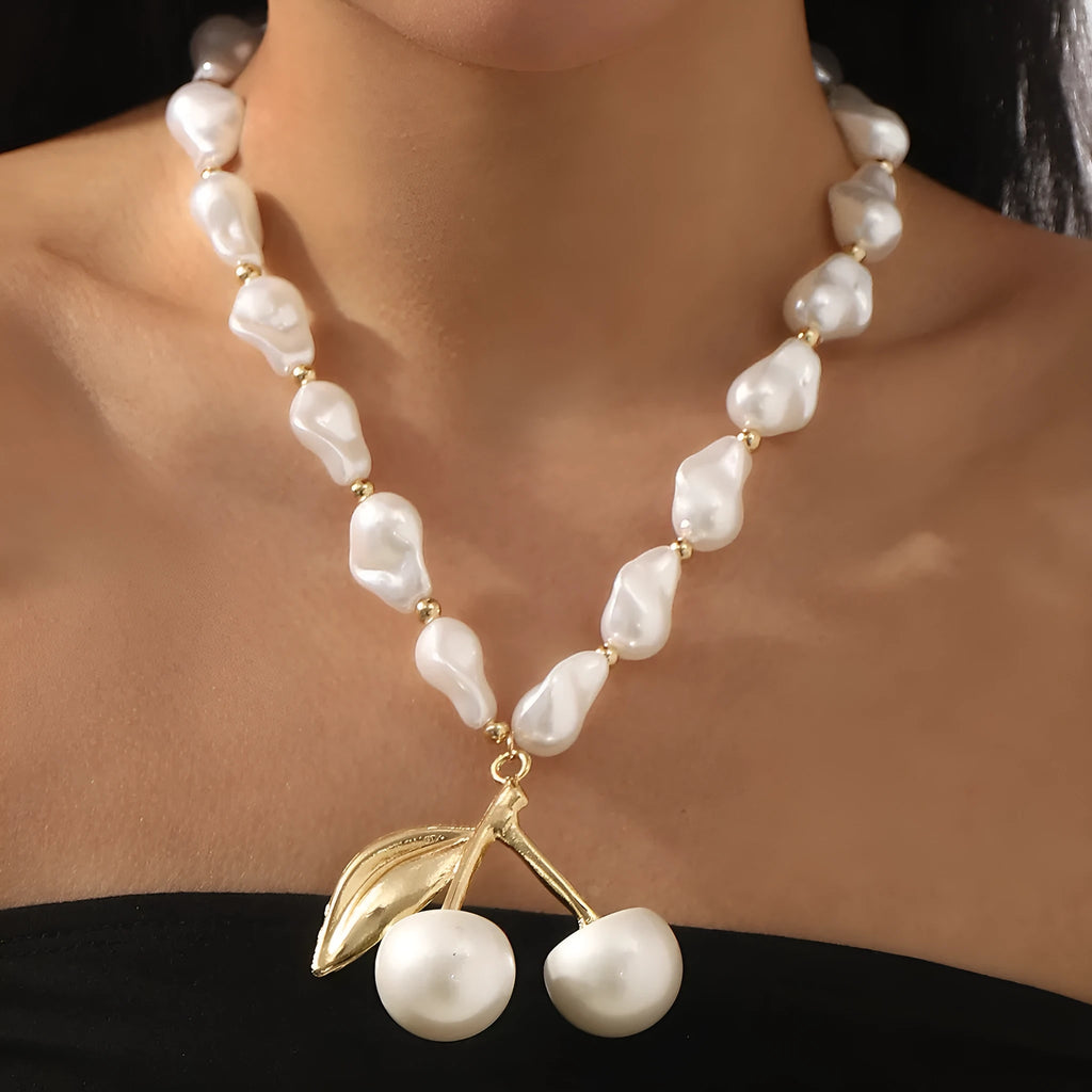 Gold coloured alloy cherry fruit pendant on an adjustable imitation pearl necklace for women.