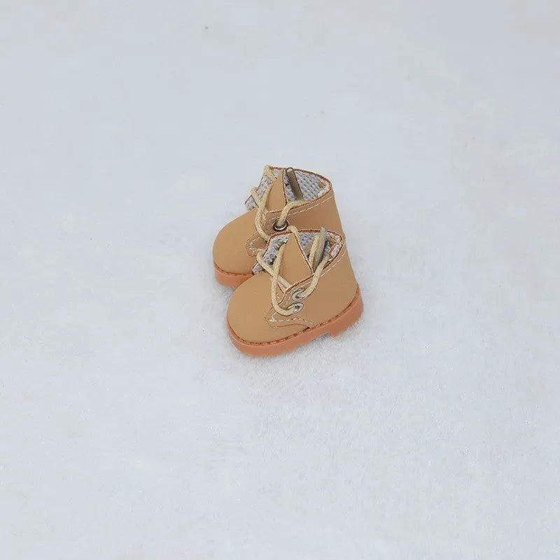 A pair of miniature replacement shoes for a 17cm doll, shown in a selected colour and style such as black boots or pink high heels.