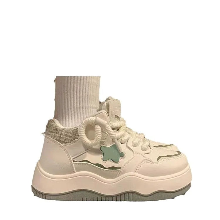 Women's green patent leather platform sneakers with round toe and lace-up front on a rubber sole.