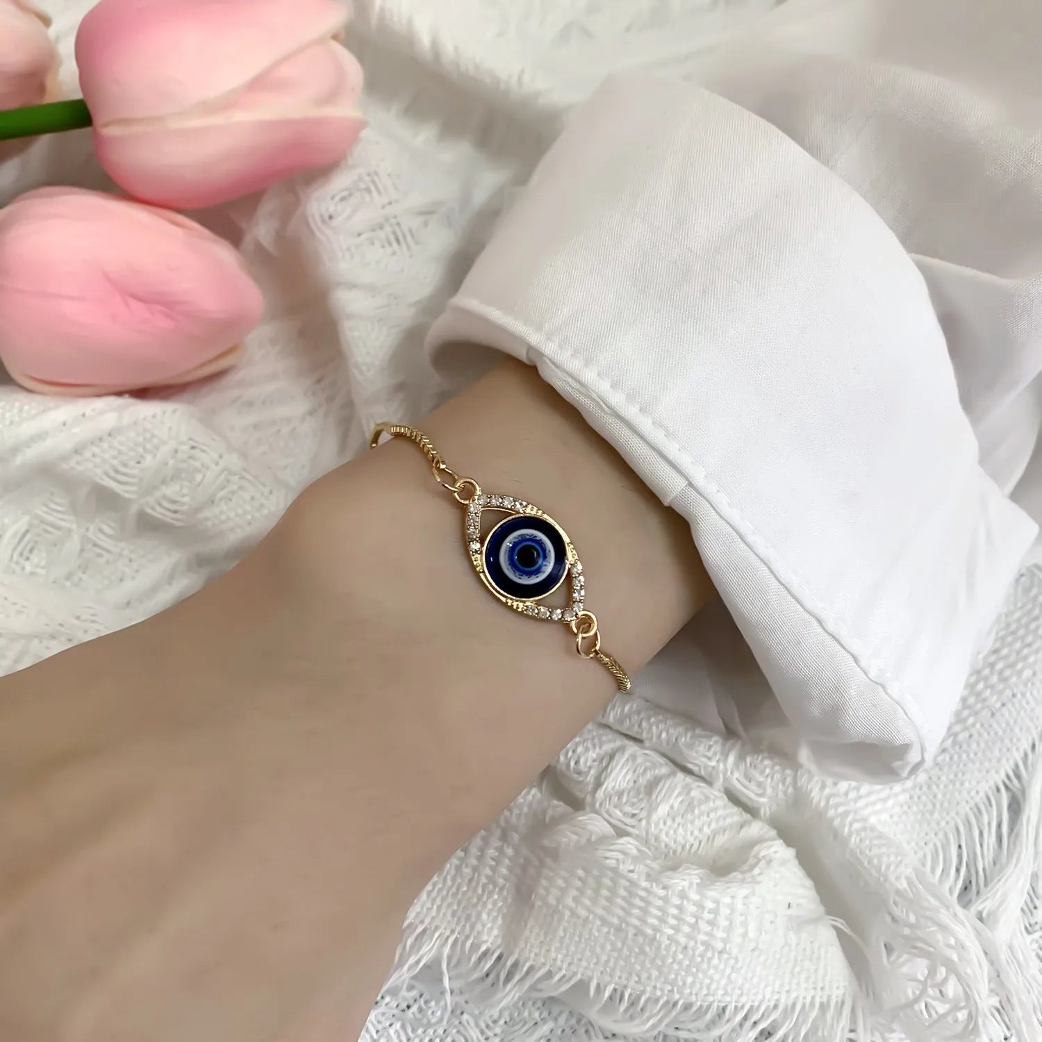 Hollow devil eye point diamond adjustable chain bracelet in stainless steel, close up of pendant
