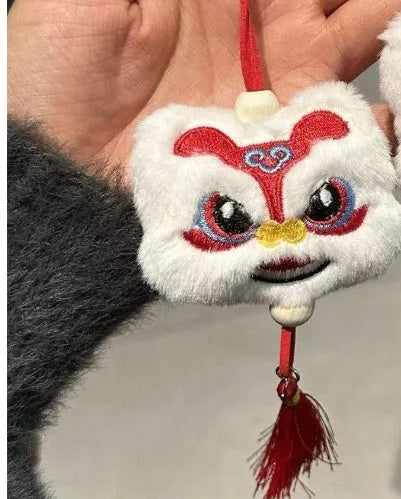 Chinese style plush lion keychain ornament with cartoon design and star stone details on blue background