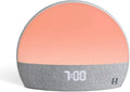 Hatch Restore smart clock in light grey with a night light and white noise machine on a bedside table