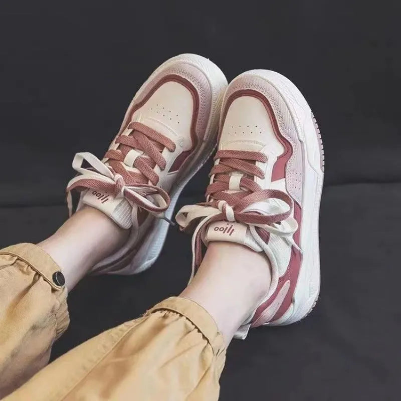 Women's pink low-top sneakers with imitation leather upper and rubber sole for hidden height increase.