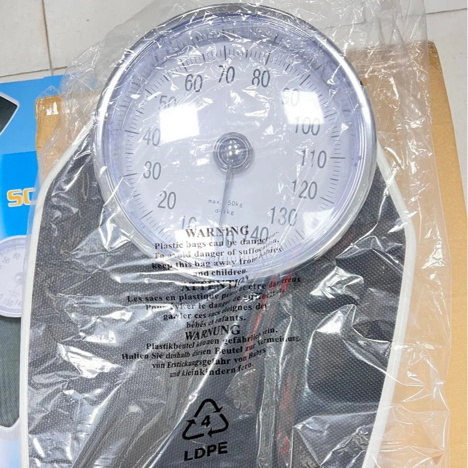 Black mechanical body weight scale with large dial showing weight measurements.