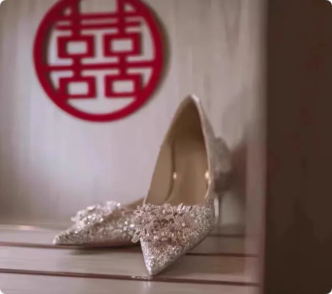 Champagne coloured pointed toe wedding heels with rhinestone floral detail on a fine heel.