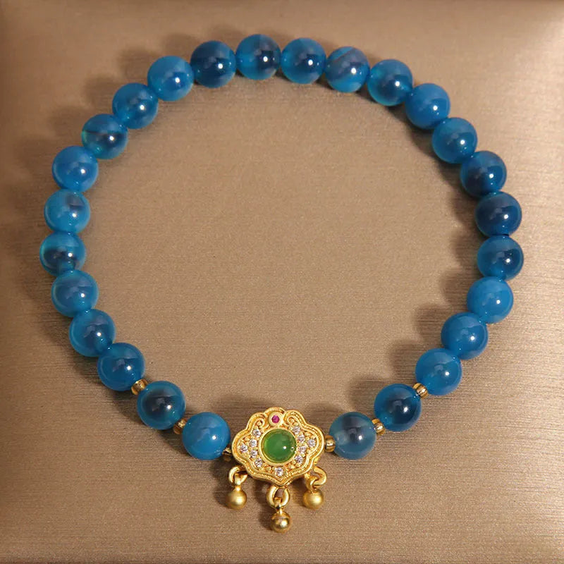 Blue agate safety lock pendant on a crystal women's bracelet with rhinestone details.