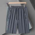 Men's black quick-drying nylon sports shorts with a loose fit and mid-thigh length on a grey background.