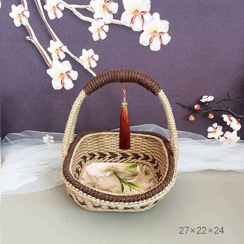 Coffee brown hand-woven straw basket with hemp rope handle, shown next to a small plant for scale.