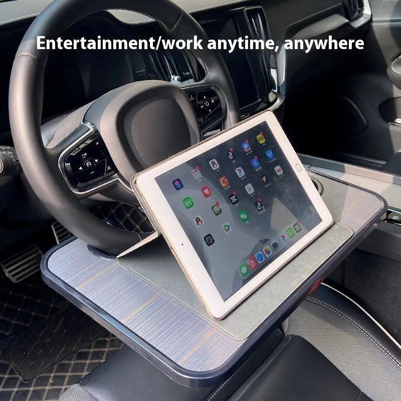 Black ABS car steering wheel laptop stand with foldable drink holder mounted in vehicle