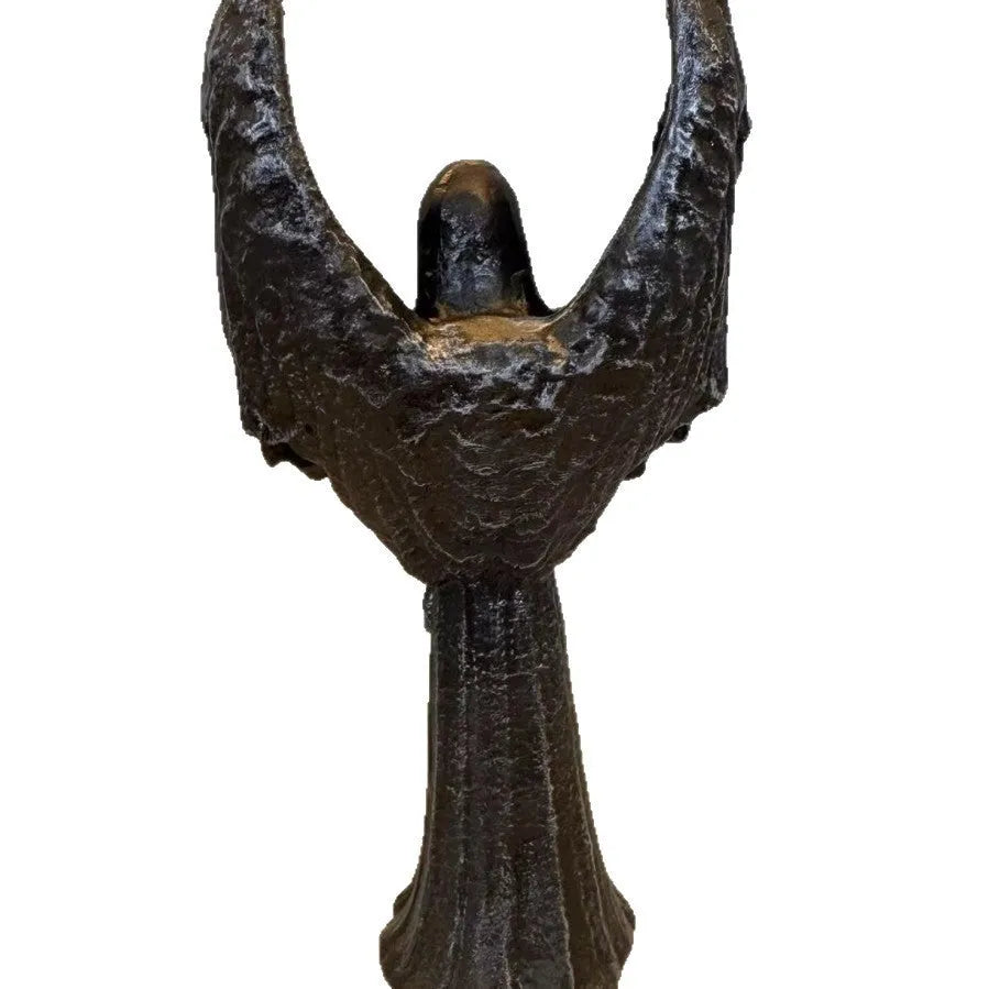 Small dark angel resin statue ornament on a table, showing detailed wings and robe.
