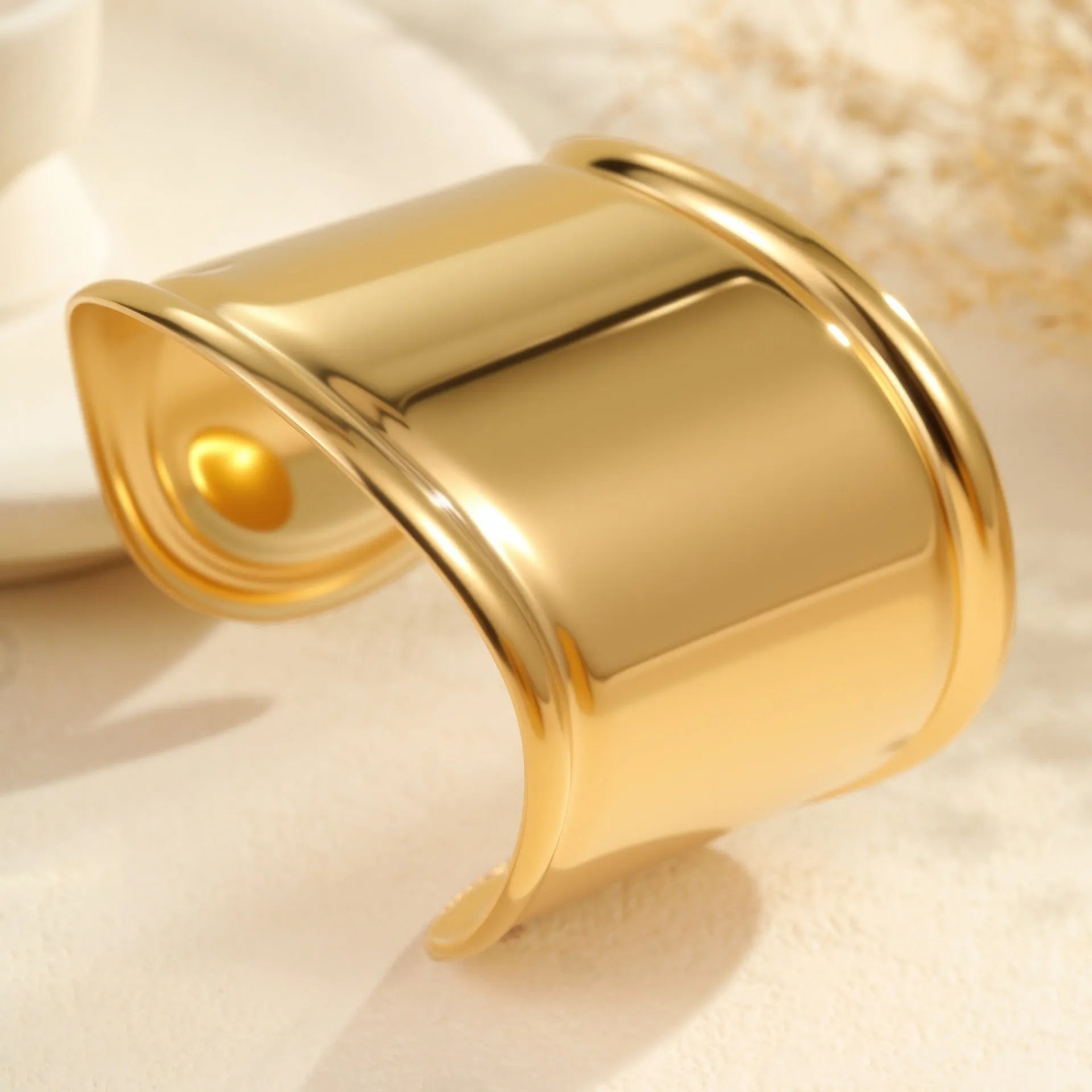 Women's wide stainless steel bracelet with geometric wave modelling and gold plating