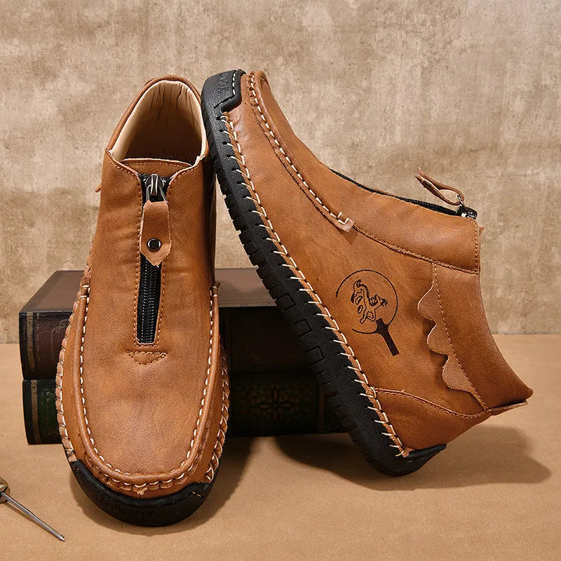Men's black slip-on leather loafers with round toe and rubber sole, shown in a casual setting.