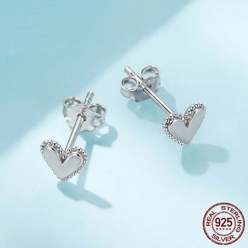 Simple S925 sterling silver heart-shaped ear studs with electroplated finish on a white background