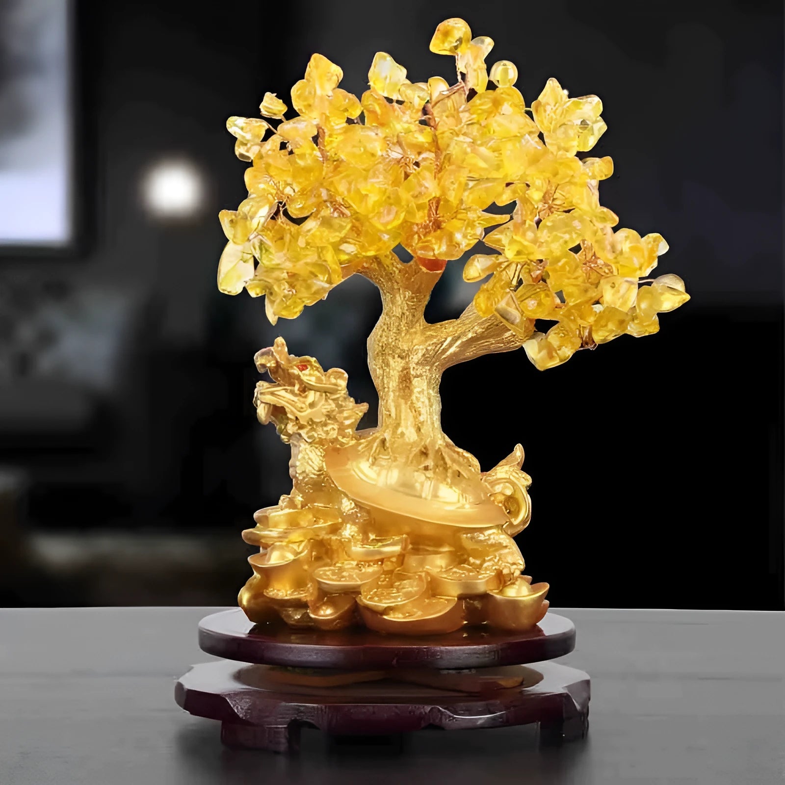 Citrine-coloured resin turtle money tree ornament on a neutral background.
