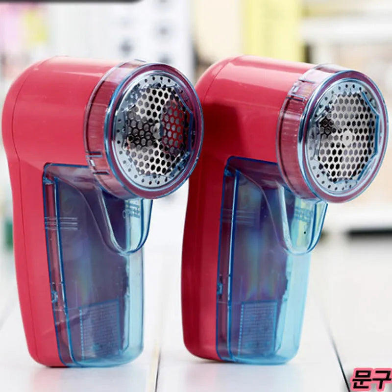 Portable electric clothing lint remover device on a sweater.