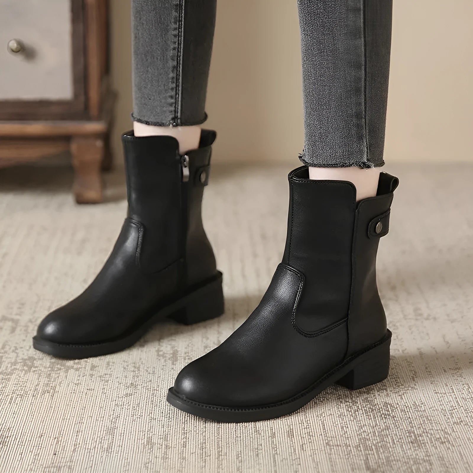 Black women's ankle boots with a side zipper, round toe, and a low rubber sole