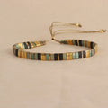 Adjustable geometric beaded bracelet with pull beads in milky white, black, green, blue or red.