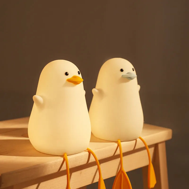 Seagull silicone night light in yellow colour with soft warm glow on bedside table