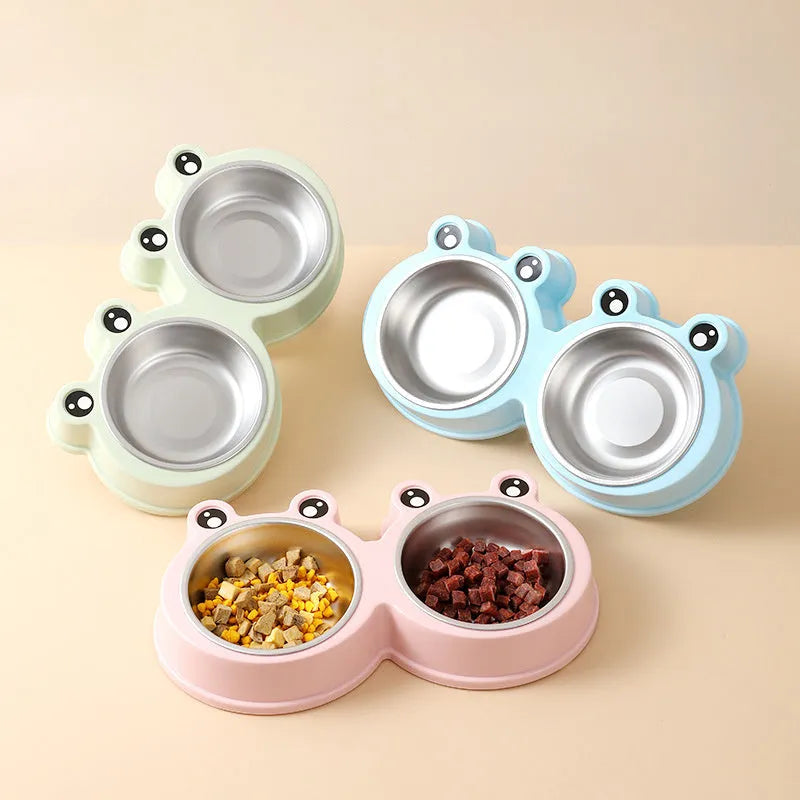 Blue stainless steel frog-shaped double pet bowl for food and water on a floor.