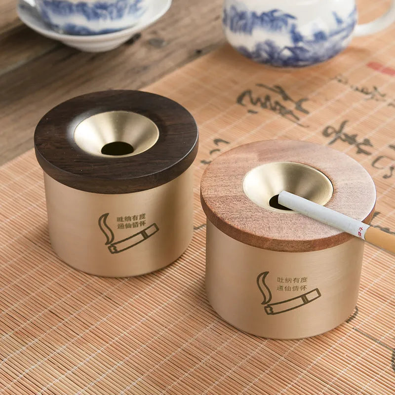 Brass ashtray with wooden lid in blackwood or rosewood finish, 6 cm diameter, on a table.