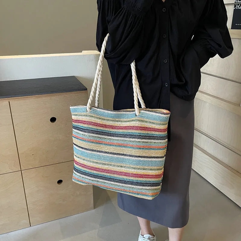 Blue woven nylon shoulder bag with an adjustable strap shown on a model.