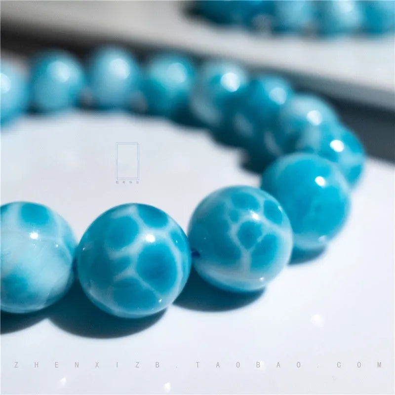 Unisex blue pearl and natural crystal sea-pattern stone bodhi bracelet on a wrist, showing Maillard style design.