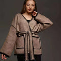Loose lace-up front knitted cardigan in camel colour, showing mid-length fit and long sleeves.