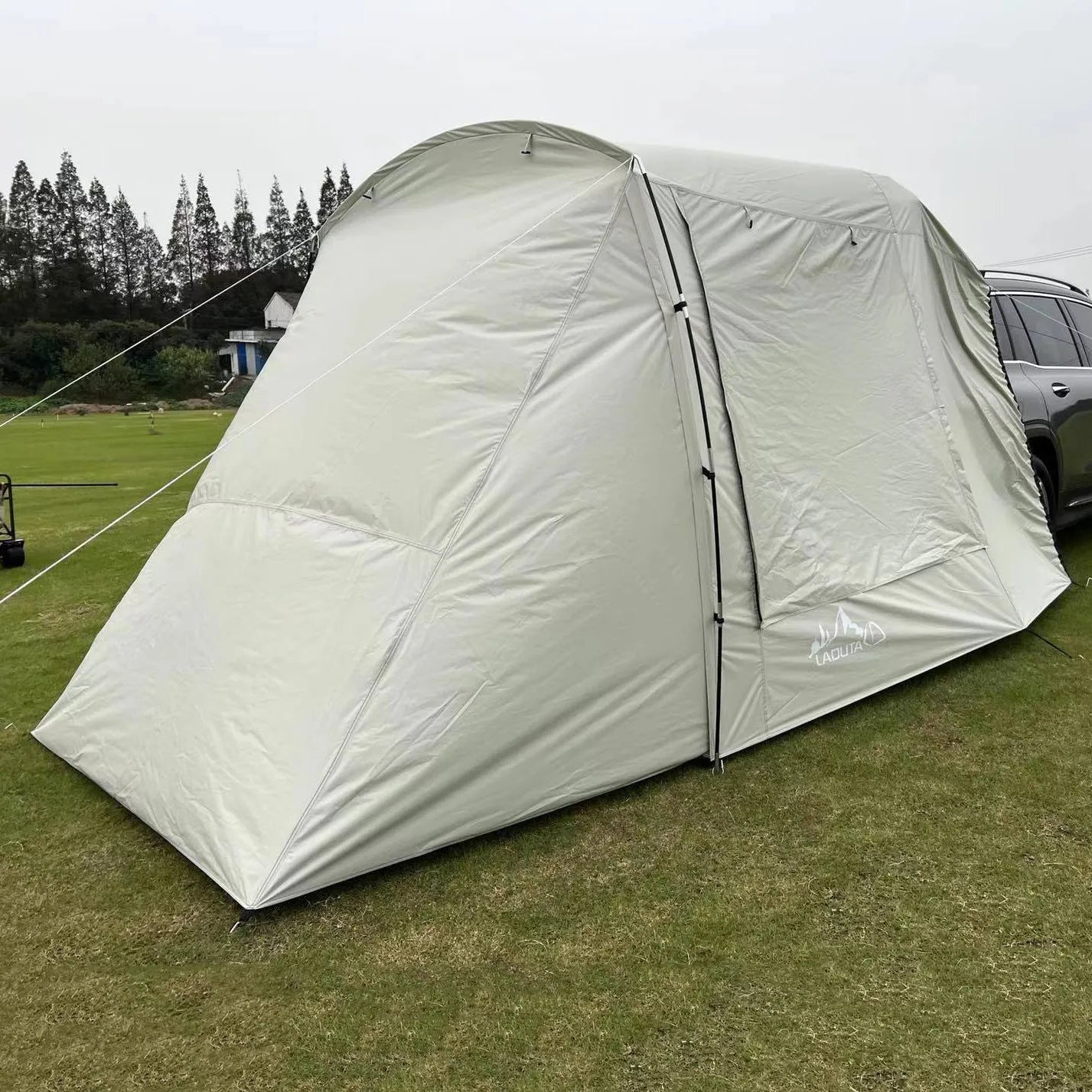 Car tail extension tent set up at a campsite with rear access, showing 190T silver-coated anti-UV fabric and screen windows.