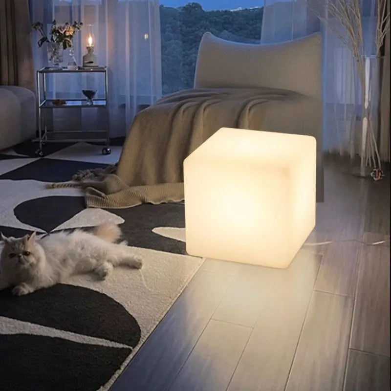 Square LED cube stool light in garden setting showing modern design with lighting